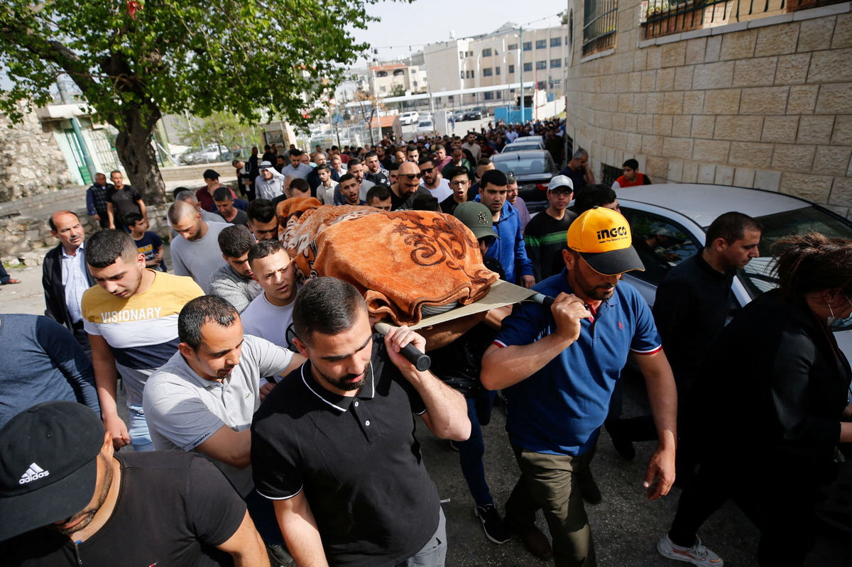 <i>MUSSA ISSA QAWASMA/REUTERS</i><br/>Mourners carry the body of Ghada Sabateen during her funeral in the West Bank village of Husan on April 10.