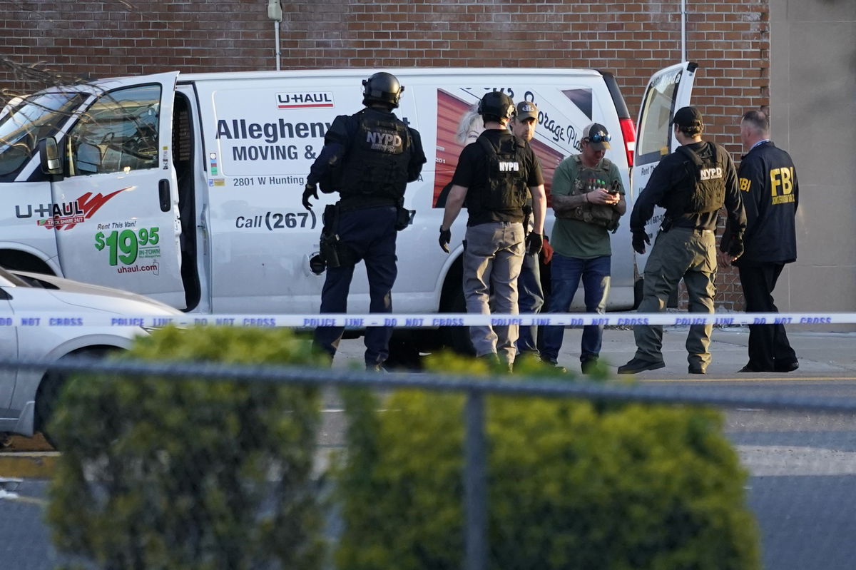 Emergency personnel including the FBI search a moving truck during an ongoing investigation in the Brooklyn borough of New York, Tuesday, April 12, 2022. Multiple people were shot and injured Tuesday at a subway station in Brooklyn during a morning rush hour attack that left wounded commuters bleeding on a train platform as others ran screaming. (AP Photo/John Minchillo)