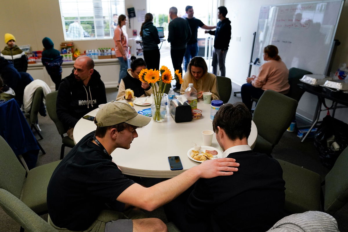 <i>Gregory Bull/AP</i><br/>Volunteer Silas Breen prays at Calvary San Diego on April 1 with David