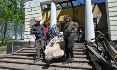 Museum workers carry the sculpture of Ukrainian philosopher Hryhorri Skovoroda from the destroyed building of the Hryhoriy Skovoroda National Literary Memorial Museum  in the village of Skovorodynivka