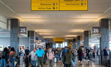 Travelers walk through the west terminal to catch their flights on May 23 in Austin