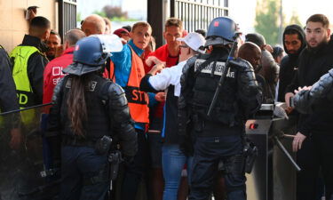 Police and stewards stand at the turnstiles as fans queue ahead of the Champions League final.