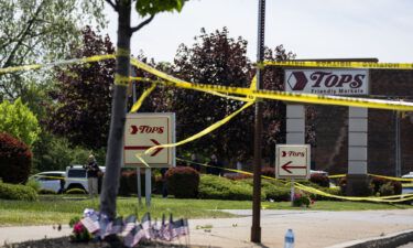 People gather outside the police tape at Tops Friendly Market at Jefferson Avenue and Riley Street on May 15