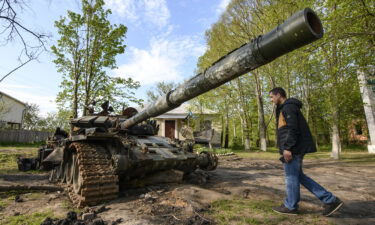 Local resident looks at the Russian military tank destroyed during Russia's invasion in Ukraine