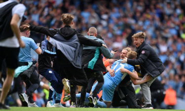 Kevin De Bruyne is mobbed by Manchester City fans after the club wins the Premier League.