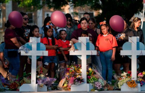People gather at a memorial site to pay their respects for the victims killed in this week's elementary school shooting in Uvalde