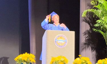 Zander Moricz takes off his hat and shows his curly hair during the graduation ceremony for Park View School to bring attention to Florida's "Don't Say Gay" law.