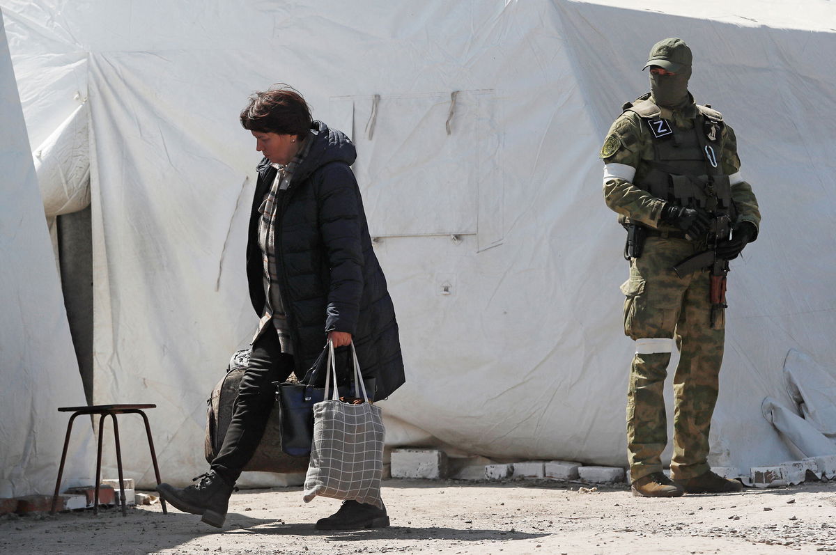 <i>Alexander Ermochenko/Reuters</i><br/>A woman carries bags as evacuees