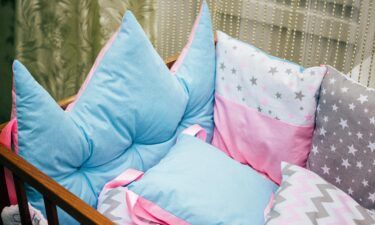 Cots and pillows and bumpers of different colors. Turquoise pillow