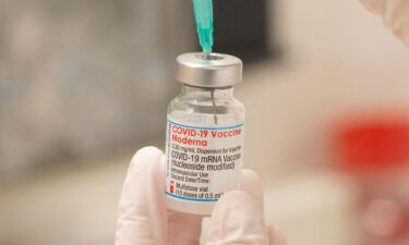 A healthcare worker fills up a syringe with a dose of Moderna's COVID-19 vaccine for a booster shot at the vaccination reference center at the Epidemiology