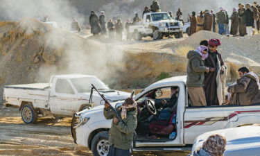 A man celebrates the end of the Wadi Zalaga annual camel race by shooting with a rifle in Sinai