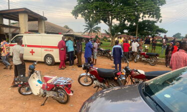 Relatives of churchgoers who were attacked by gunmen during church service gather as health workers attend to victims brought in by ambulance after the attack at St. Francis Catholic Church