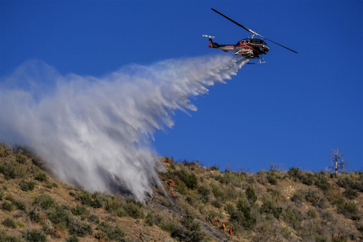 <i>Ringo H.W. Chiu/AP</i><br/>A helicopter drops water on the Sheep Fire burning in Wrightwood