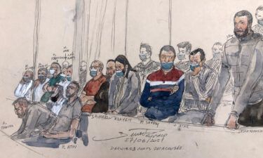 This court-sketch made on Monday shows defendant Salah Abdeslam (right) standing next to the 13 other defendants in front of Paris' criminal court during the trial of the November 2015 attacks that saw 130 people killed.