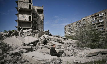 A boy sits on the rubble of a building hit in a strike on Kramatorsk