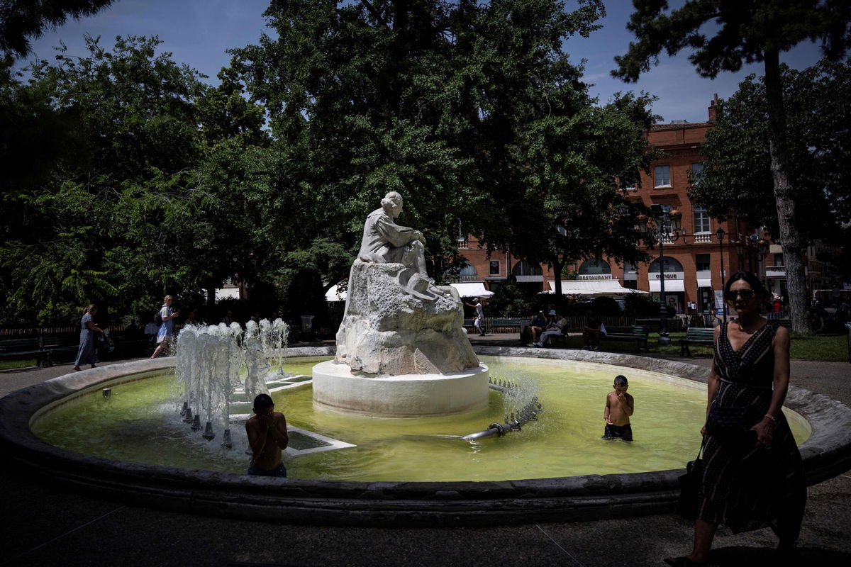 <i>Lionel Bonaventure/AFP/Getty Images</i><br/>A pedestrian walks past as children play in a fountain in the city centre of Toulouse