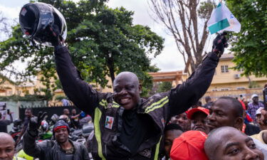 Kunle Adeyanju (C) celebrates with supporters after arriving at the Ikeja Rotary club in Lagos on May 29 after a 41 day trip from London