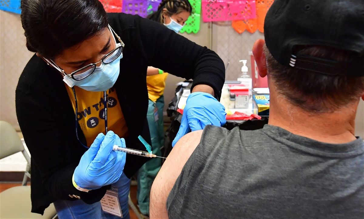 <i>Frederic J. Brown/AFP/Getty Images</i><br/>Registered Nurse Mariam Salaam administers the Pfizer booster shot at a Covid vaccination and testing site decorated for Cinco de Mayo at Ted Watkins Park in Los Angeles on May 5.