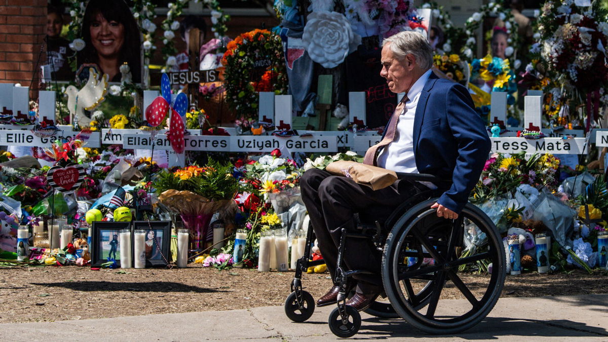 <i>CHANDAN KHANNA/AFP via Getty Images</i><br/>Texas Gov. Greg Abbott visits a makeshift memorial outside Robb Elementary School on May 29.