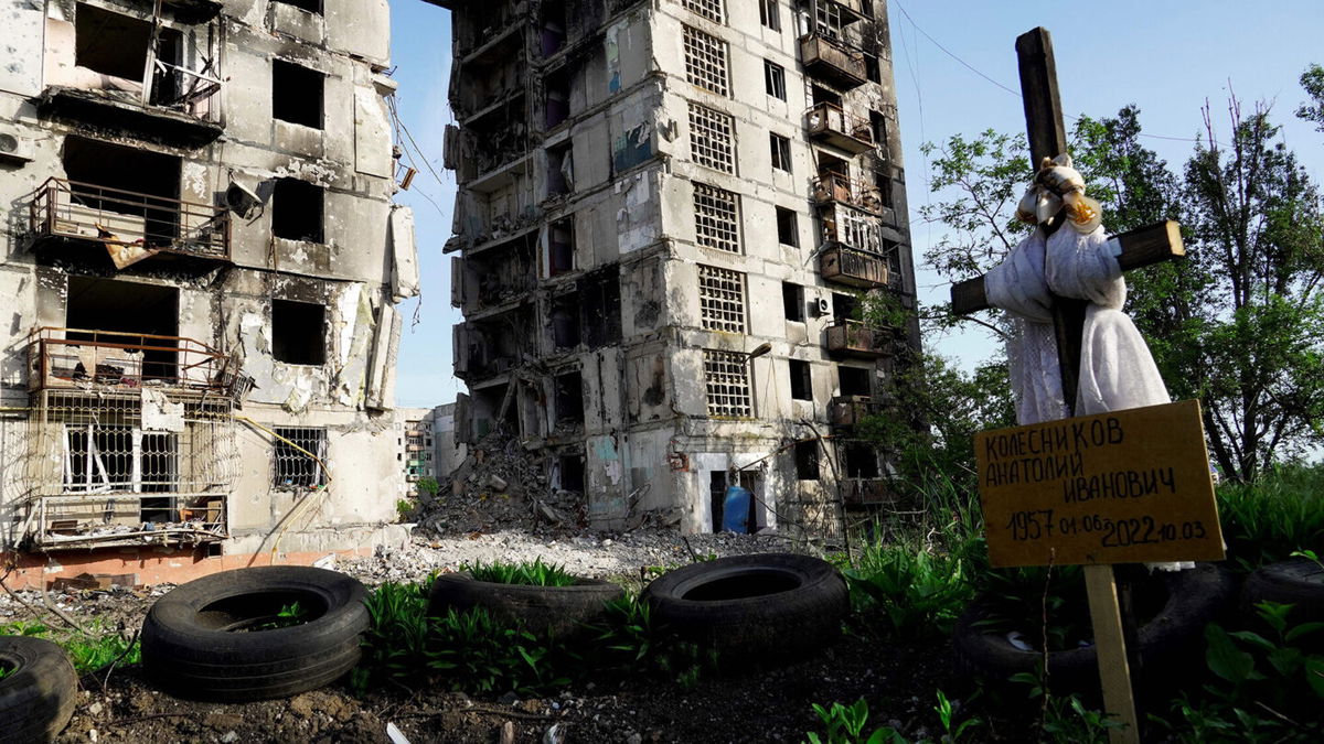 <i>AFP/Getty Images</i><br/>A grave is pictured in front of destroyed residential buildings in Mariupol on May 31