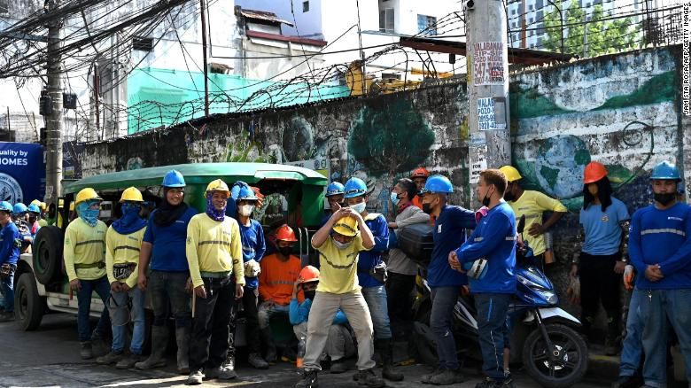 Construction workers evacuate a building after a 7.1-magnitude earthquake, some 400 kilometers away, was felt in Manila on July 27.