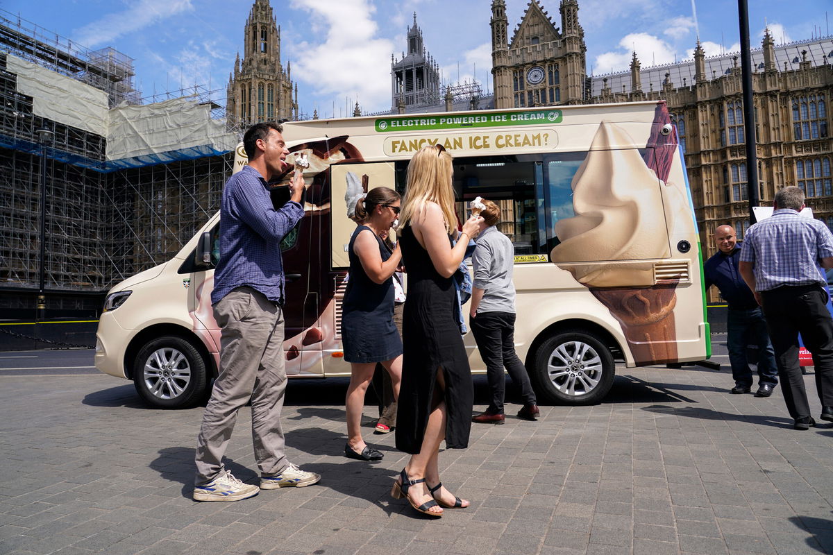 <i>Alberto Pezzali/AP</i><br/>People eat ice cream outside the houses of Parliament in London on July 13.