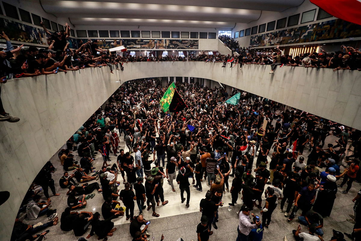 <i>Ahmad Al-Rubaye/AFP/Getty Images</i><br/>Protesters cheer after entering Iraq's parliament on Saturday.