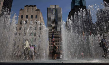 People play in the water sculpture at Rockefeller Center Plaza in New York on July 19.