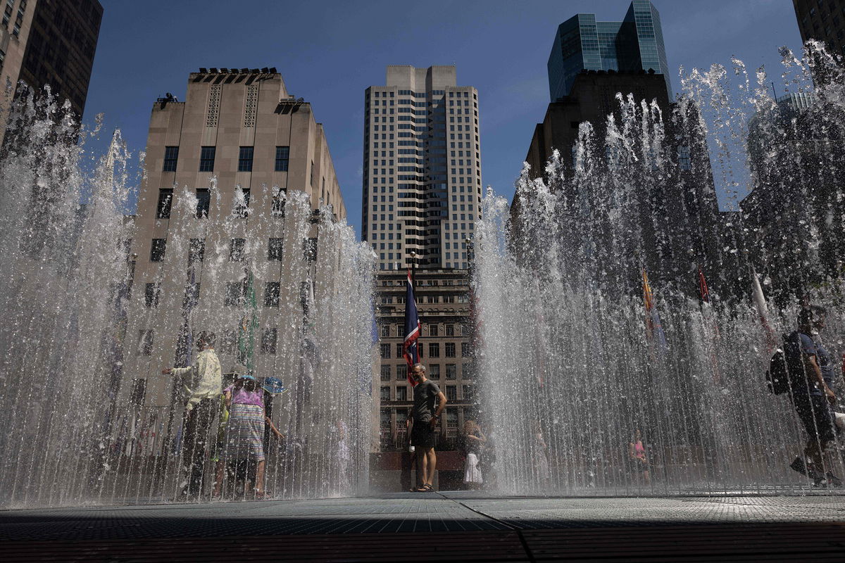 <i>Yuki Iwamura/AFP/Getty Images</i><br/>People play in the water sculpture at Rockefeller Center Plaza in New York on July 19.