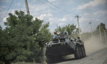 Ukrainian servicemen are seen riding on top of a tank towards the battlefield in Siversk frontline