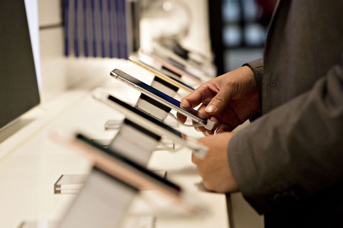 <i>Daniel Acker/Bloomberg/Getty Images</i><br/>A shopper looks over a display of iPhones at a T-Mobile store in Chicago