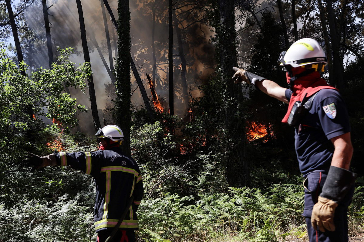 <i>Thibaud Moritz/AFP/Getty Images</i><br/>Firefighters work to extinguish a wildfire which broke out at the bottom of the Dune du Pilat near Teste-de-Buch