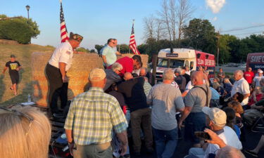 A group of people attending Rep. Lee Zeldin's speech gather around an alleged attacker in Fairport