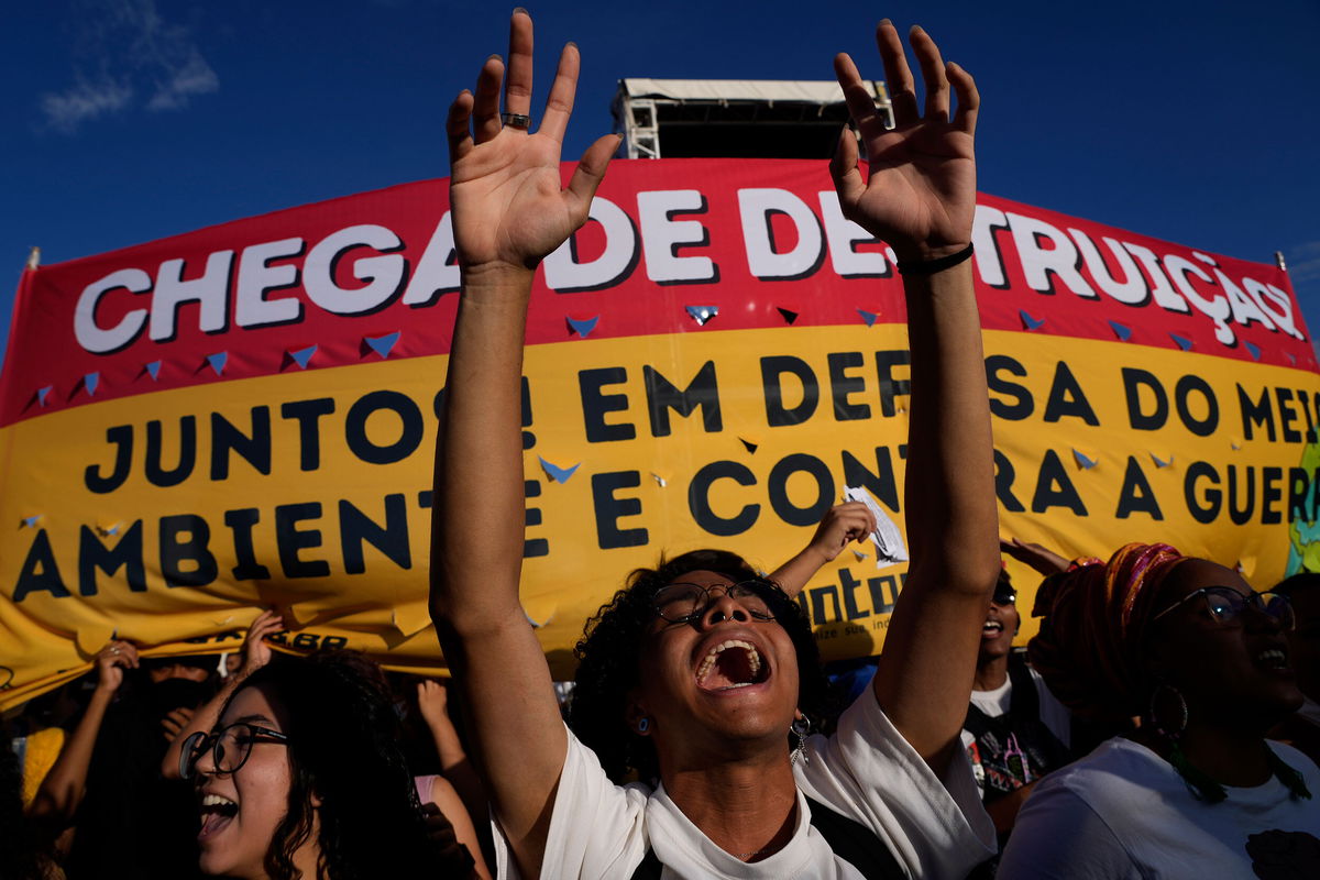 <i>Eraldo Peres/AP</i><br/>Environmental activists protest against Brazilian President Jair Bolsonaro on March 9. Brazil's Amazon rainforest has been deforested by a record amount in the first half of 2022