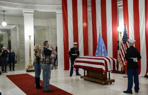 People salute the casket of Hershel "Woody" Williams set up in the first floor rotunda of the West Virginia State Capitol in Charleston