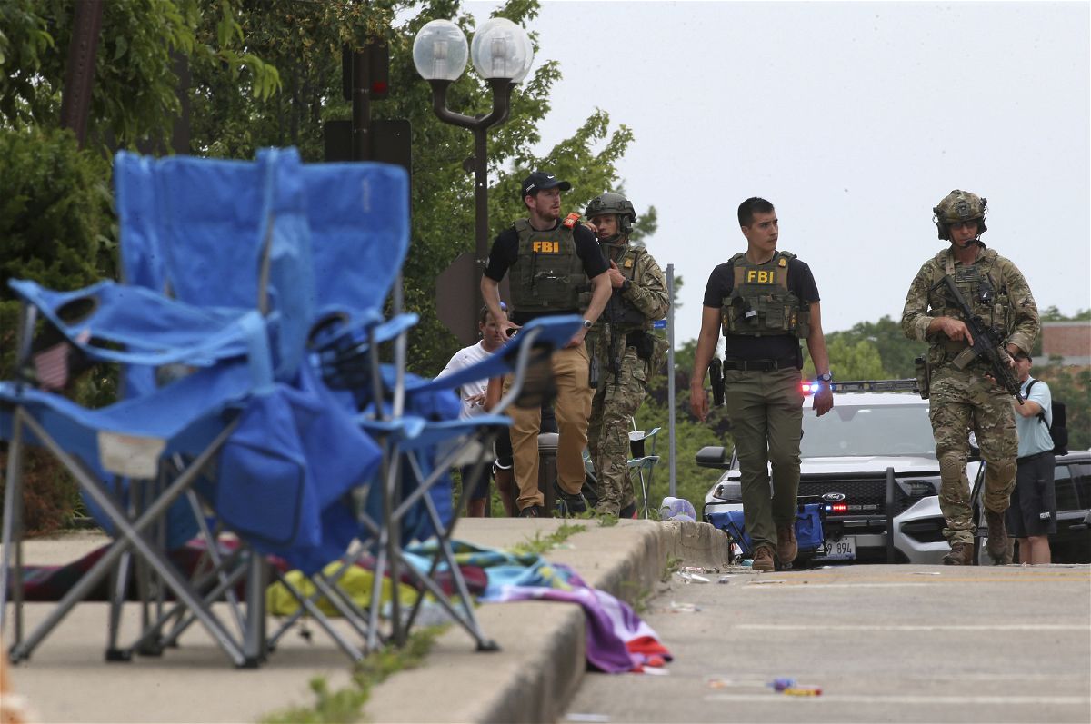 Law enforcement officers from multiple jurisdictions investigate the area in Highland Park, Illinois, on Monday, July 4, 2022, after a shooter fired on the Chicago suburbâs Fourth of July parade. (Antonio Perez/Chicago Tribune/Tribune News Service via Getty Images)