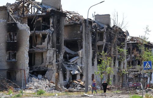 Local residents walk past apartment buildings destroyed during Ukraine-Russia conflict in the city of Sievierodonetsk in the Luhansk Region