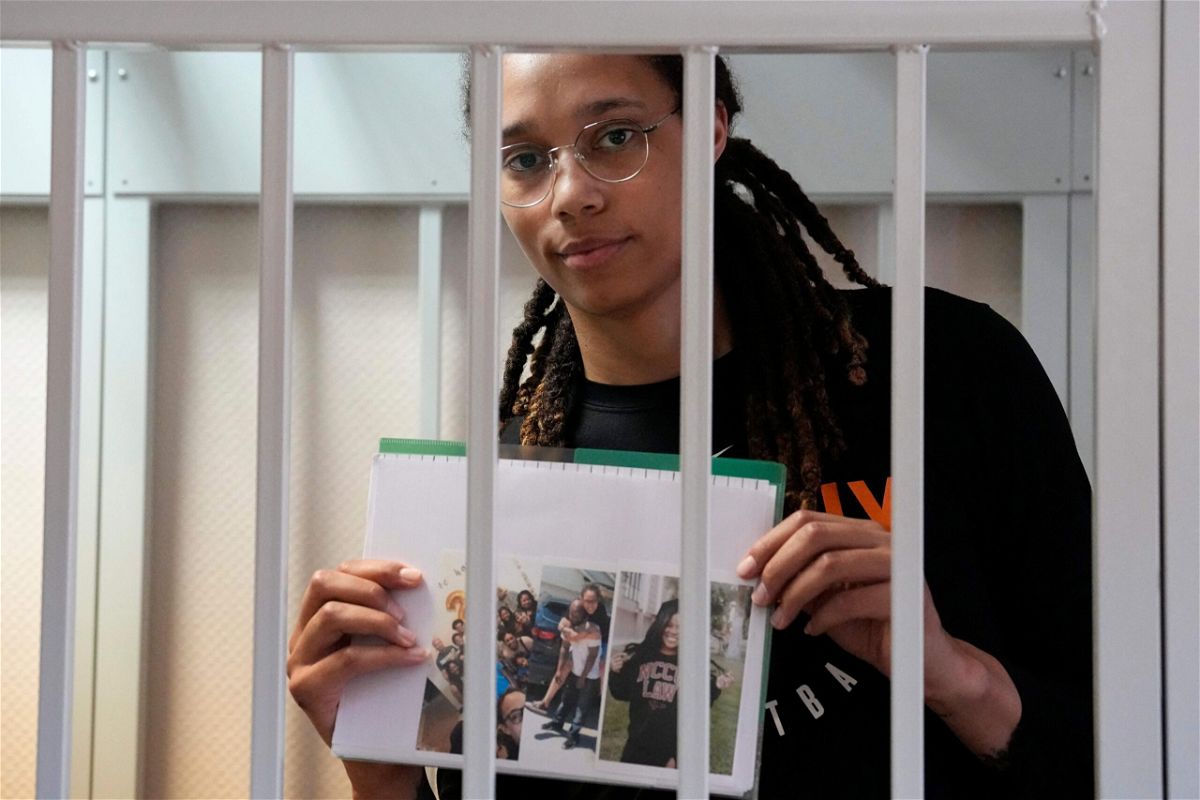 <i>Alexander Zemlianichenko/Pool/AFP/Getty Images</i><br/>Brittney Griner holds photographs standing inside a defendant's cage before a hearing at a court outside Moscow on July 27.