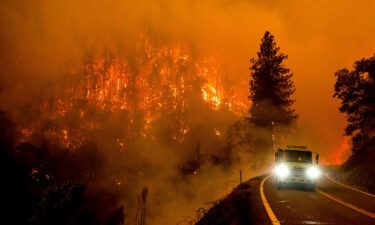 A fire truck drives along California Highway 96 as the McKinney Fire burns in Klamath National Forest