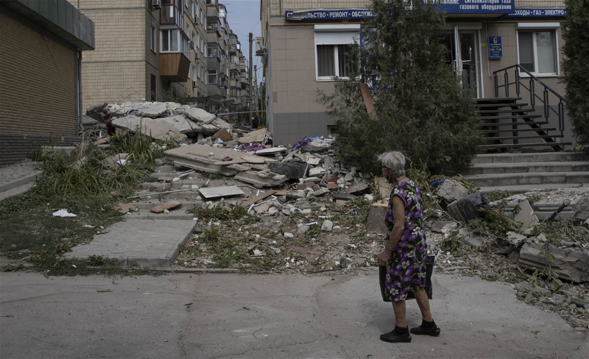 <i>Metin Aktas/Anadolu Agency/Getty Images</i><br/>A woman assesses the damage on a street in Nikopol