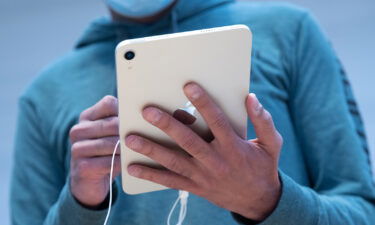 A customer uses an Apple iPad Mini tablet for sale at a store in New York in September 2021. Apple is directing users of most of its devices to update their software.