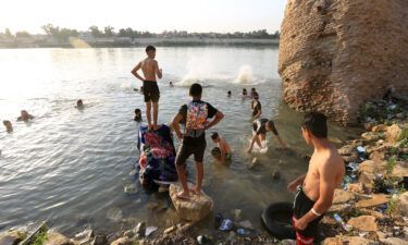 People cool off at the Tigris River during hot weather in Baghdad