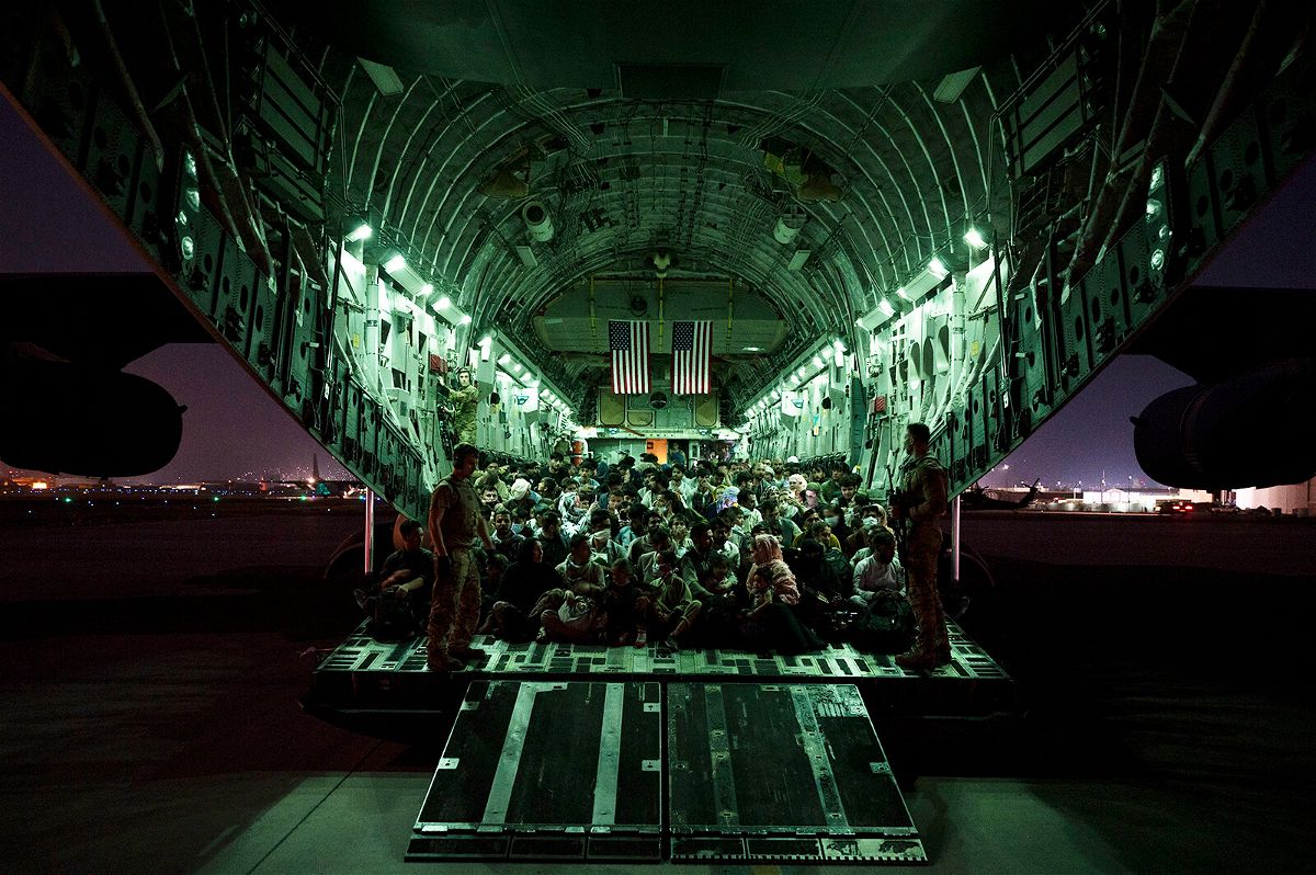<i>US Air Force/Getty Images</i><br/>An air crew assigned to the 816th Expeditionary Airlift Squadron assists evacuees aboard an aircraft in support of the Afghanistan evacuation at Hamid Karzai International Airport on August 21
