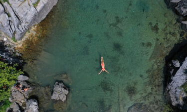 A woman swims to cool off in the Xhemas Lake