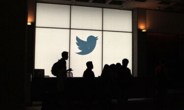 Twitter employees walk by the company's headquarters in San Francisco