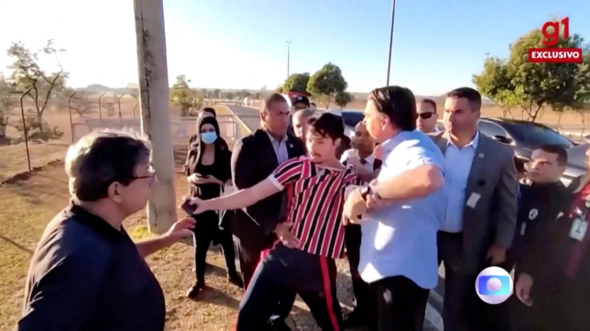 <i>TV Globo/Reuters</i><br/>Brazil's president Jair Bolsonaro grabs YouTuber Wilker Leao's shirt as Leao demonstrates against Bolsonaro's government outside the Alvorada Palace in Brasilia