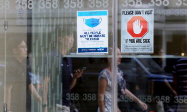 Signage requesting mask usage and Covid-19 safety precautions are displayed at a building on July 9 in New York City.