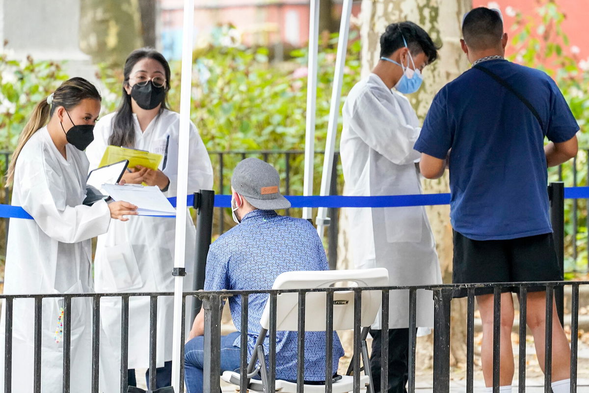 <i>Mary Altaffer/AP</i><br/>Healthcare workers with the New York City Department of Health and Mental Hygiene help people register for the monkeypox vaccine at a city vaccination site on July 26.