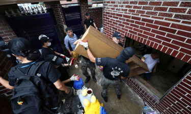 Soldiers carry debris out from a flooded house in Seoul