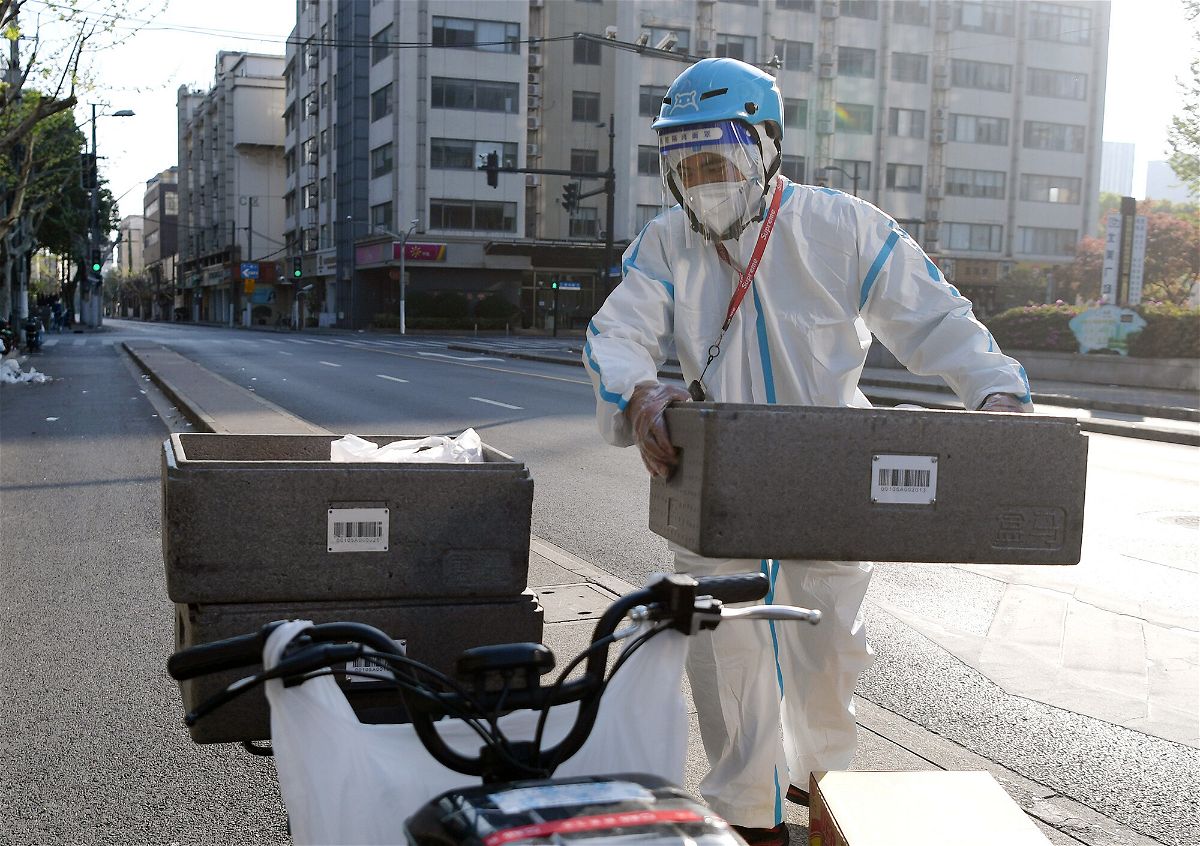 <i>Li He/Xinhua/Getty Images</i><br/>A deliveryman loads food packages on his bike in Shanghai